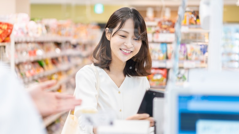 Japanese woman doing semi self-checkout