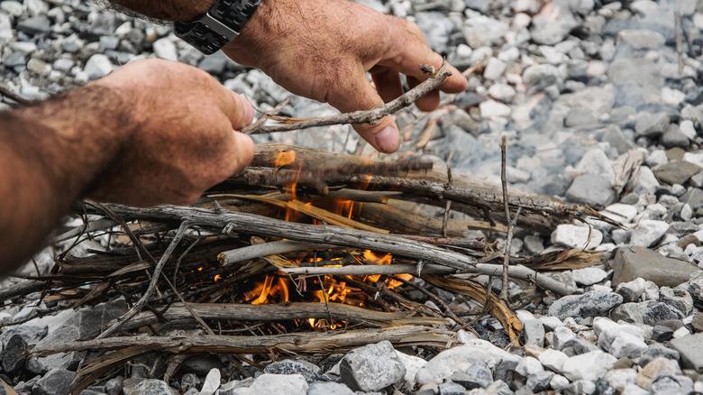 person's hands making a fire