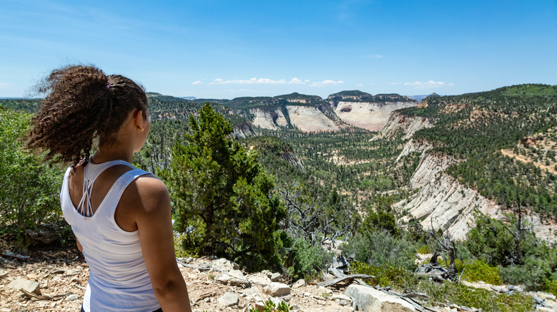 girl overlooking forested canyon 