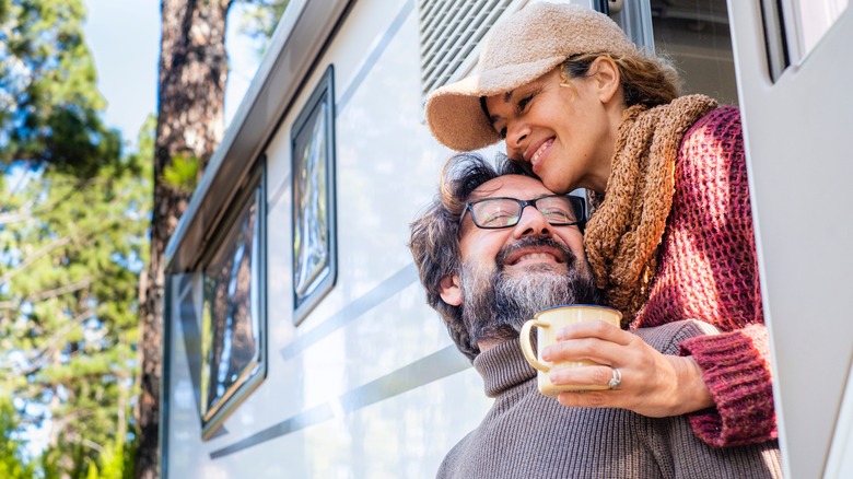 couple in RV near large trees