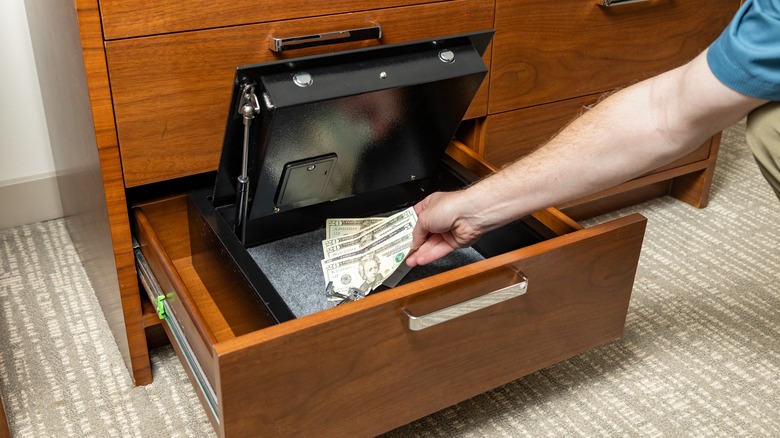 Man putting money in a locked box