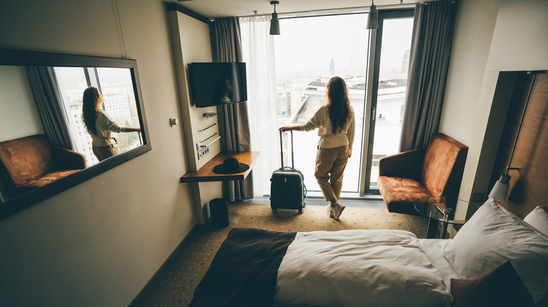 Woman with luggage in a hotel room