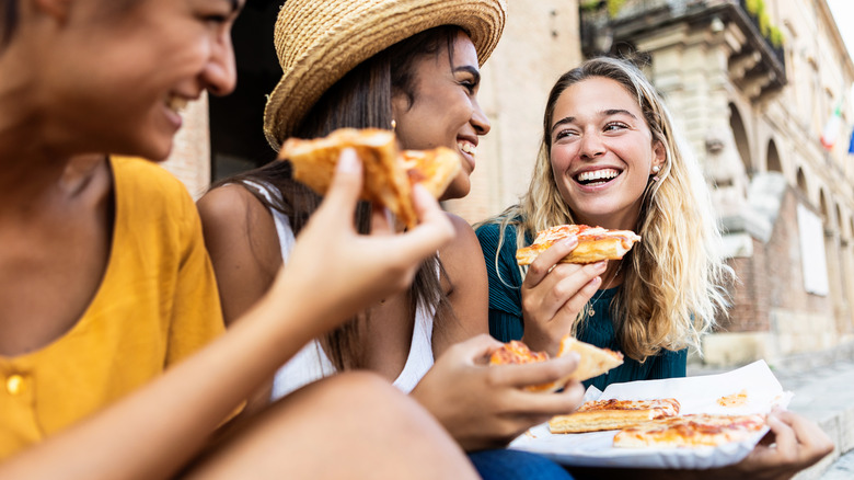 women eating pizza in Italy