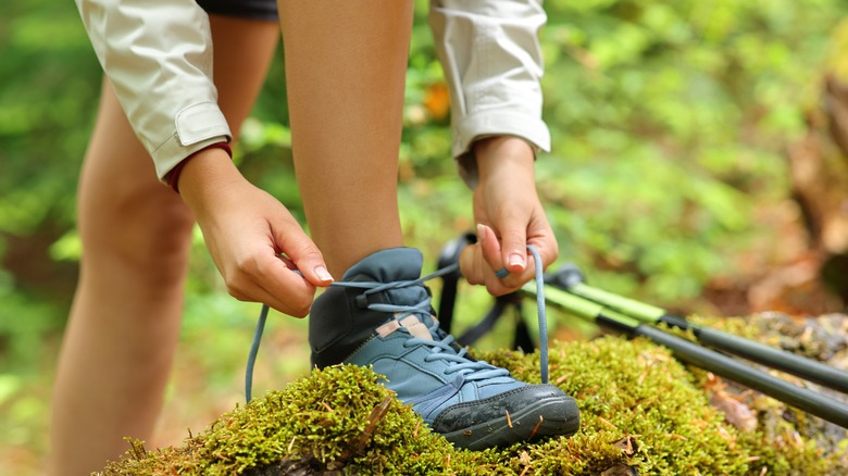 person tying hiking boot laces