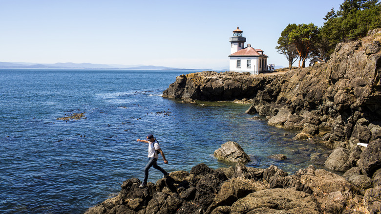 Person walking on rocks by Lime Kiln Light