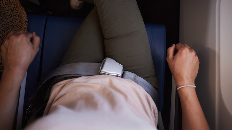 Person gripping plane seat