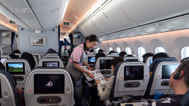 JAL flight attendant speaks to passenger