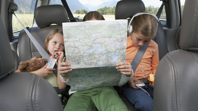 kids in backseat reading map