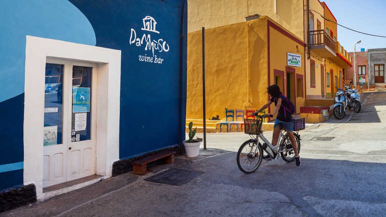 Person cycling by Dammuso Bar in Linosa