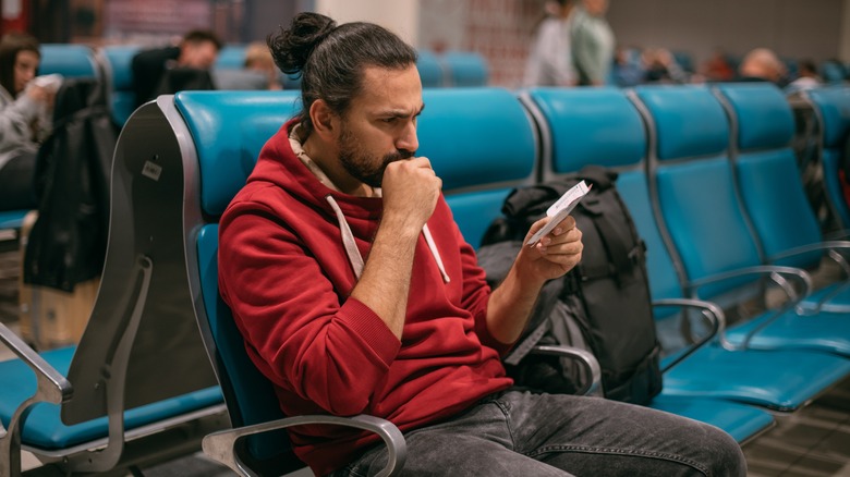 Man looking at boarding pass