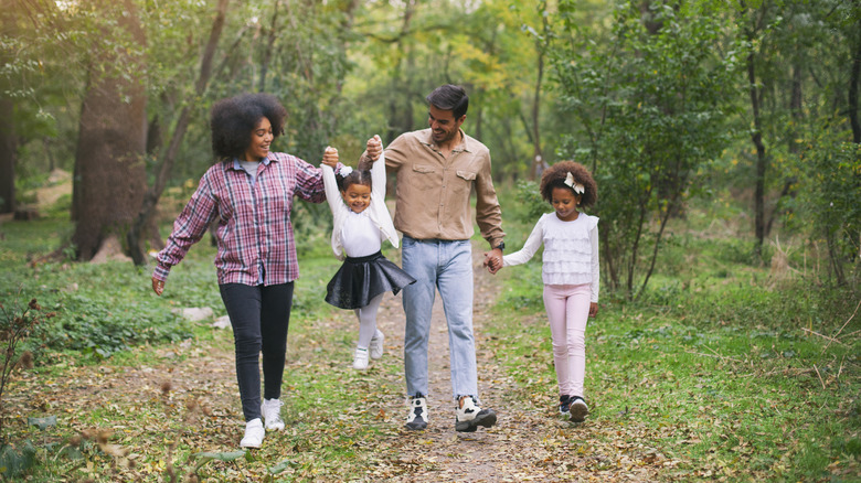 family walking on wooded trail