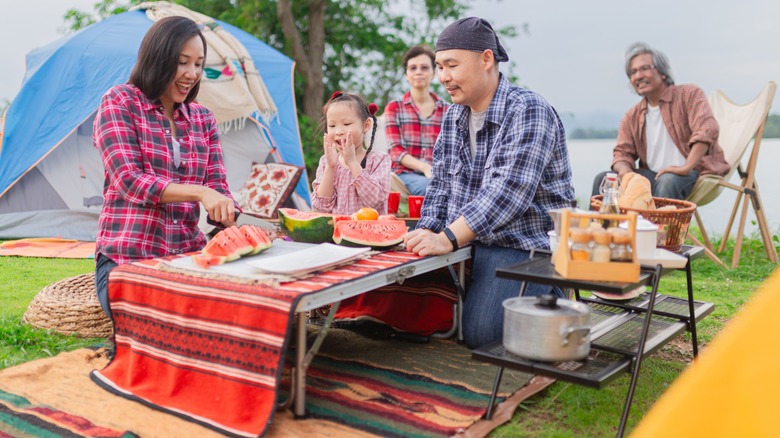 A family enjoying a lakeside picnic while camping