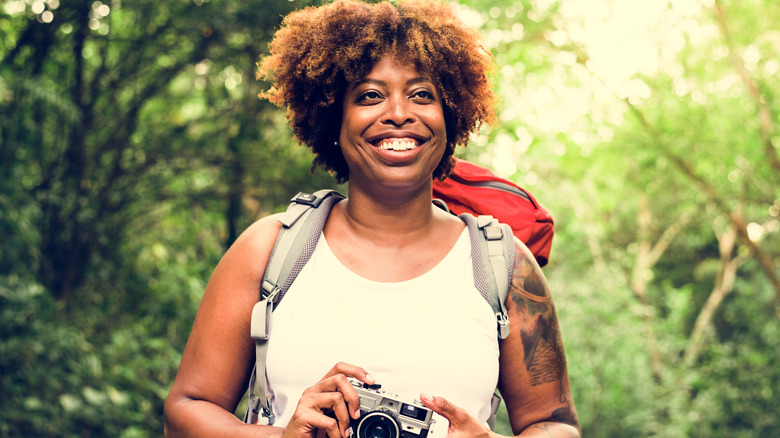 Female hiker holding a camera 