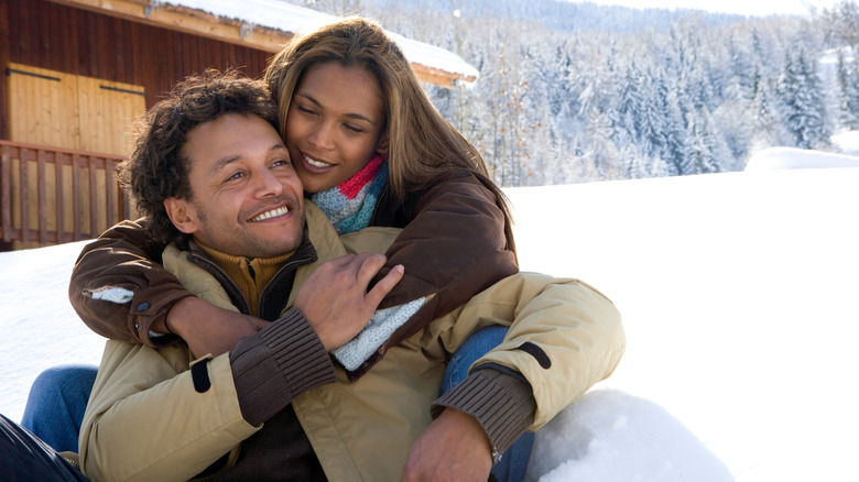 couple outside cabin in snow