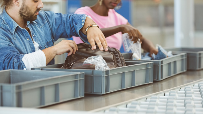 travelers with airport security bins