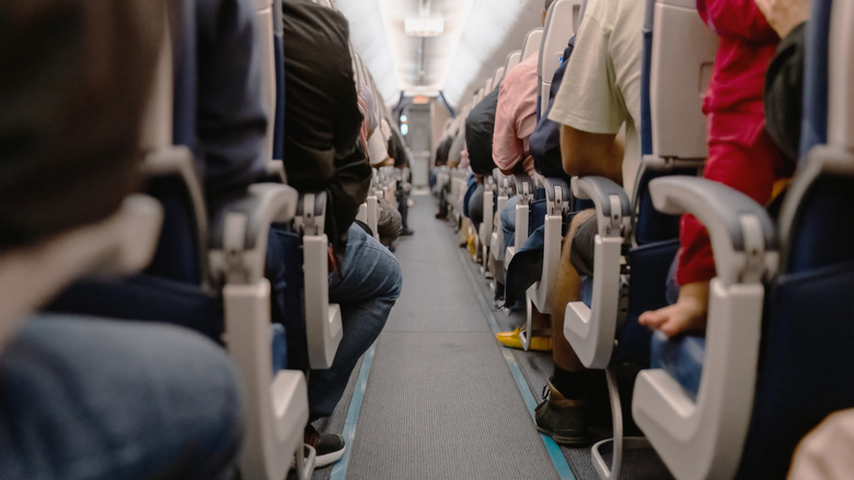 plane cabin aisle with passengers