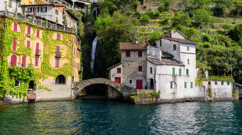 Small waterfall and bridge nestled between Italian houses