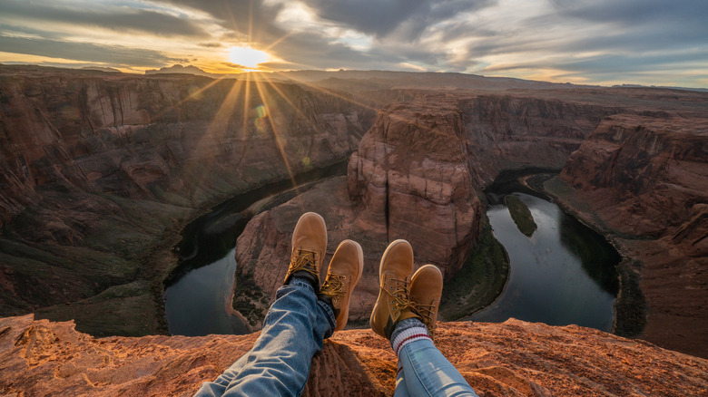 hikers' feet on edge of canyon