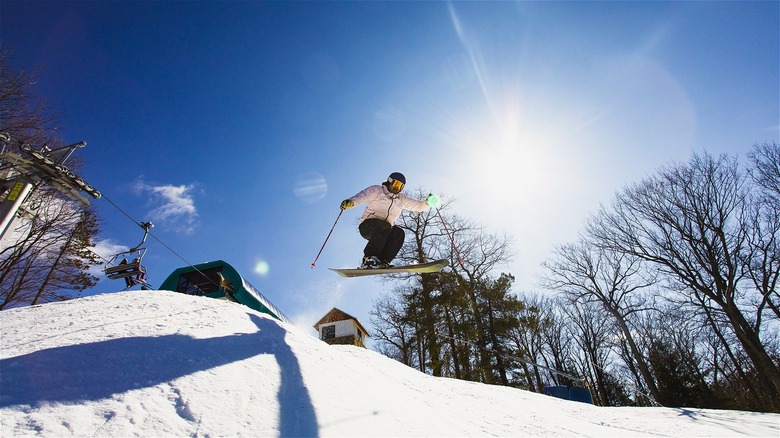 A snowboarder jumps over a mountain