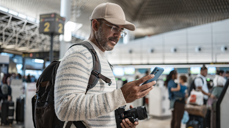 man at airport using phone