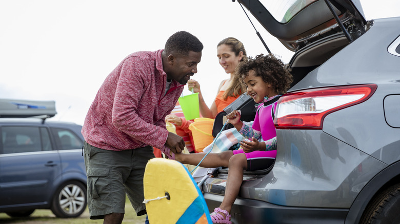 family unloading car at beach