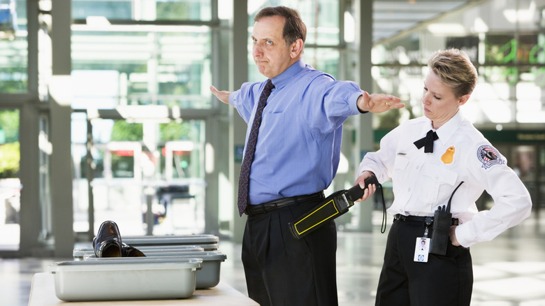 A man being screened by TSA.