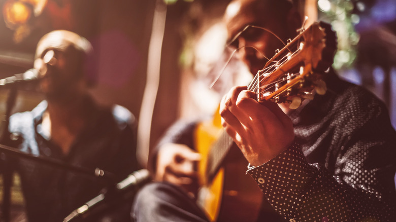 Musicians playing a guitar and singing