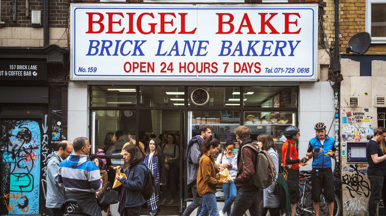 People passing Beigel Bake storefront