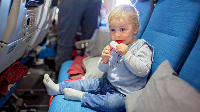 baby with toy on plane