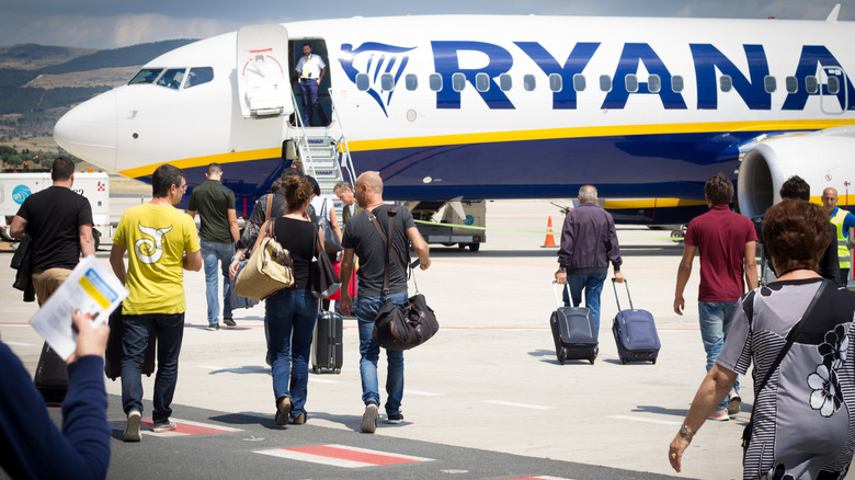 Passengers walking toward a Ryanair plane.