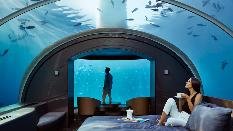 Couple watching the fish in the underwater bedroom at Conrad Maldives Rangali Island
