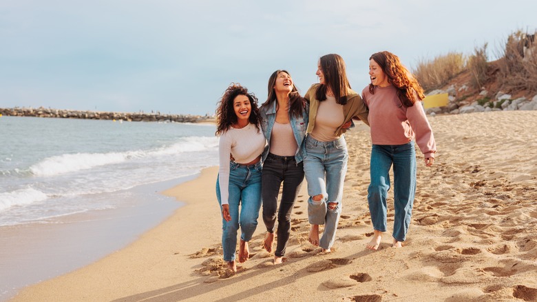 group of friends walking on beach