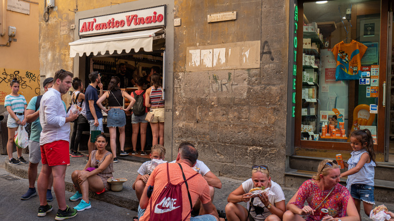 A crowd eating outside of the All'antico Vinaio panini shop