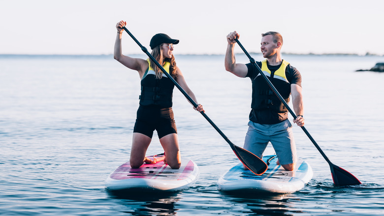 Happy couple paddleboarding