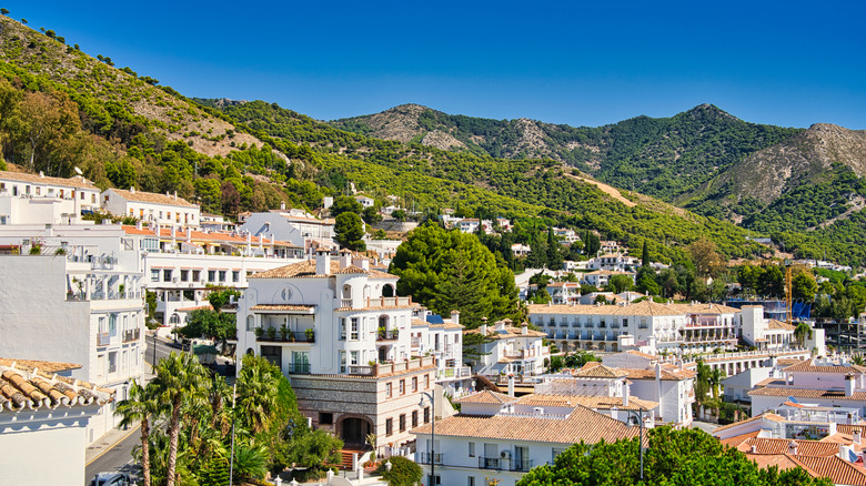 view of white buildings tucked in green Spanish mountainside