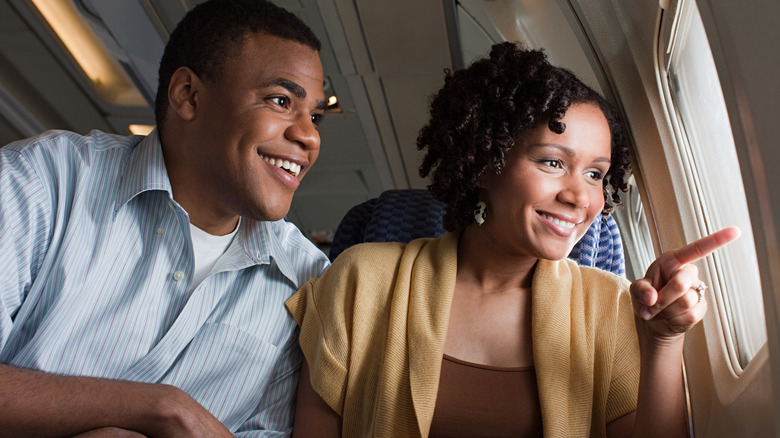 Passengers looking out airplane window