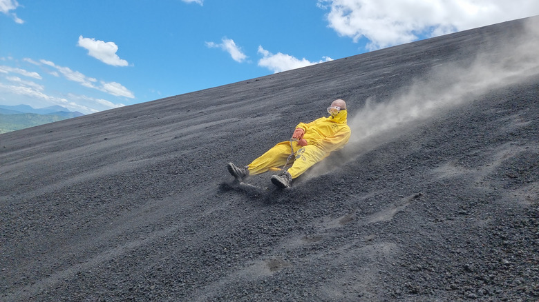 Person rides a sandboard down the volcanic ash of Cerro Negro