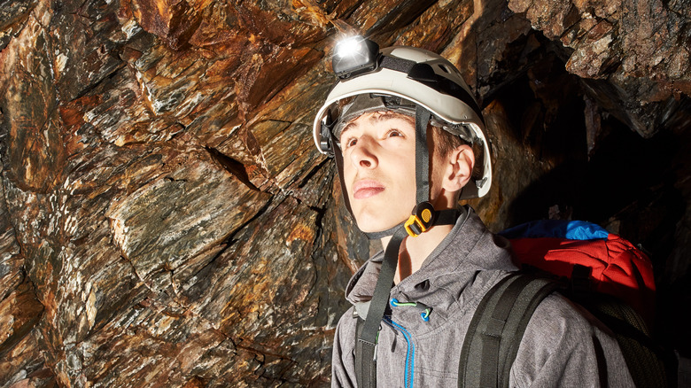 Caver with headlamp and helmet