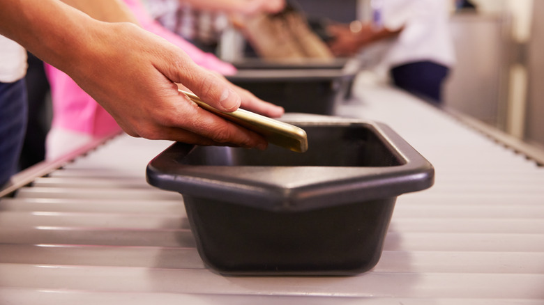 Hand placing phone in bin