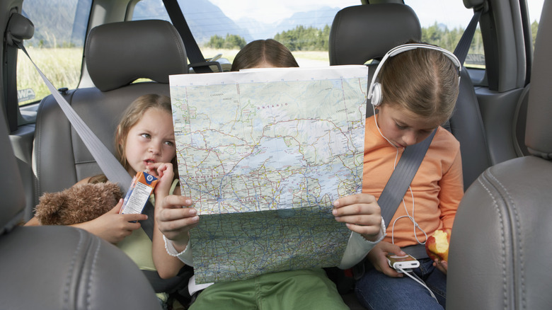 kids in back of car with map
