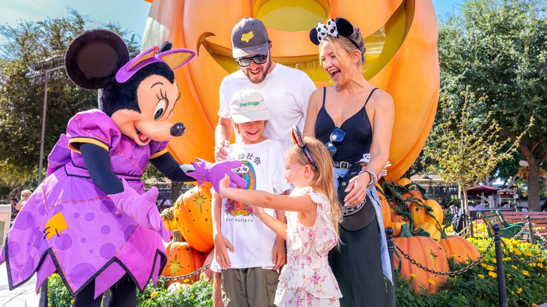Family with young children meeting Mickey Mouse