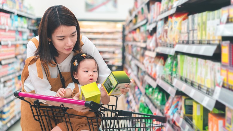 woman grocery shopping with baby