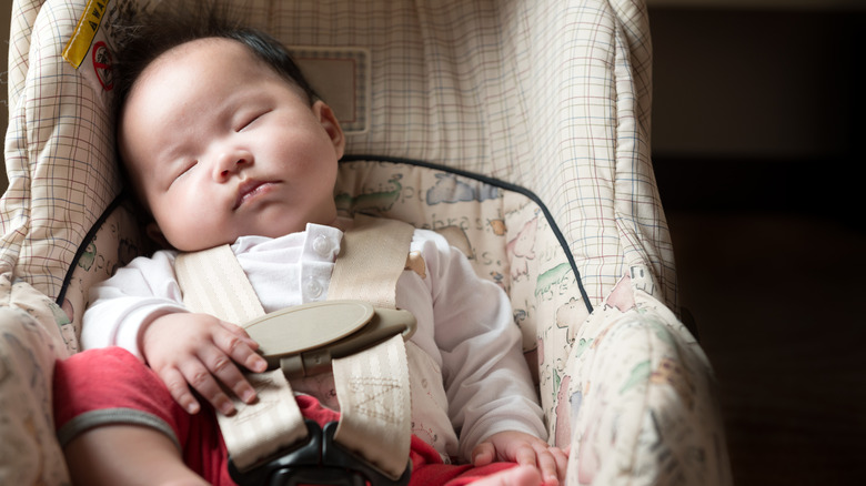 newborn sleeping in car