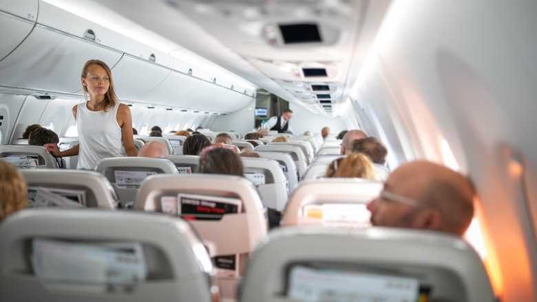 woman walking down airplane aisle