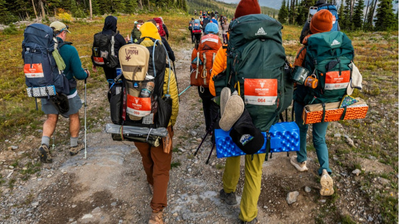 Group of hikers marching down a trail.