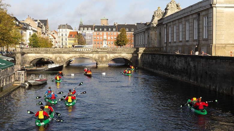 Kayakers paddle around a Copenhagen canal.