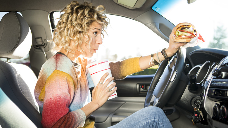 woman eating and drinking while driving