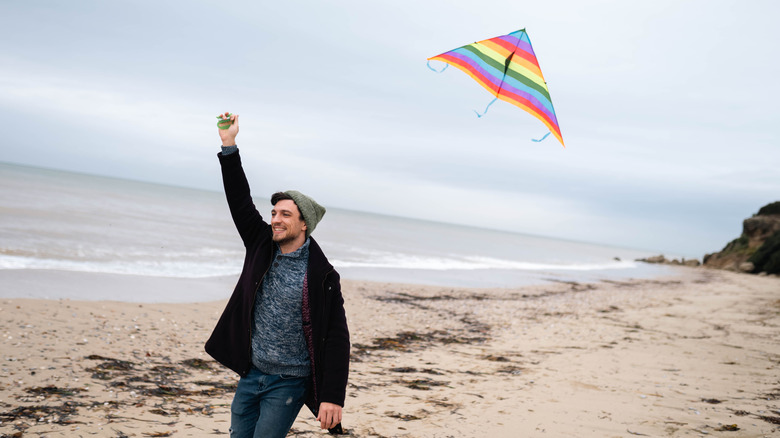 man flying a kite on beach