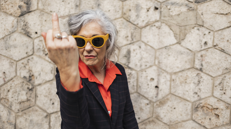 older woman sticking up middle finger