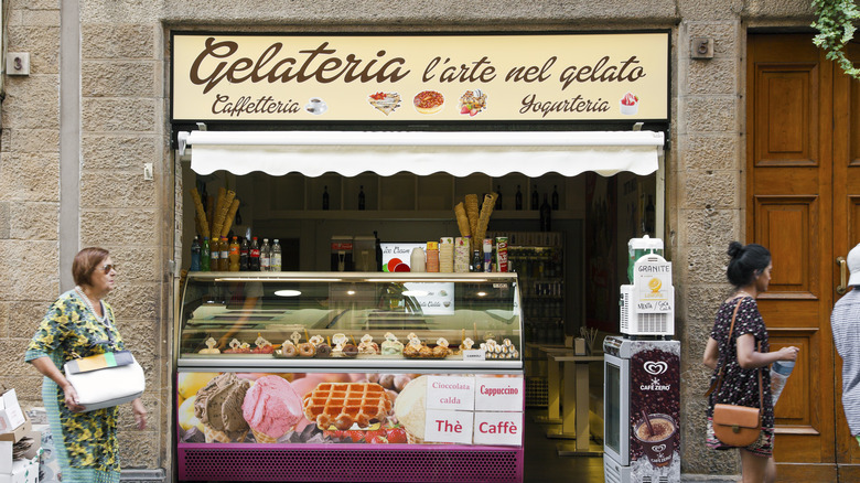 people passing a small gelateria